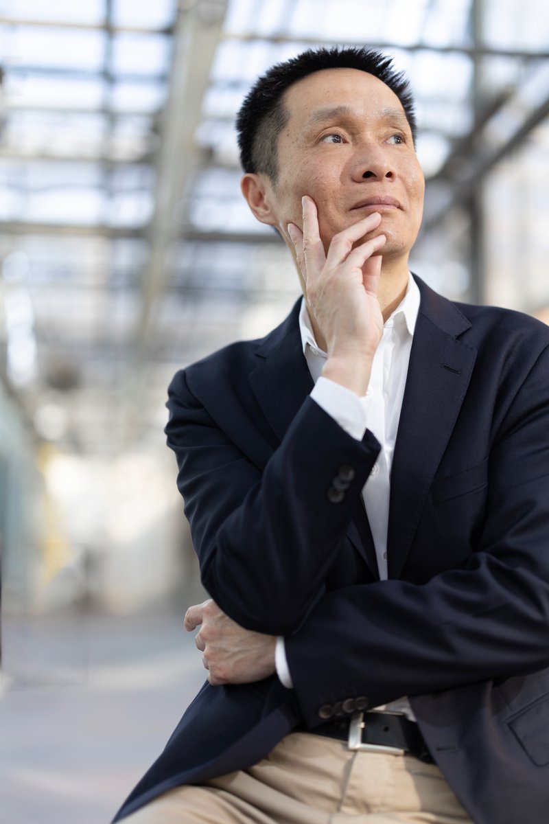 chrismichel's tweet photo. Professor Chuan He works at the edge of a quiet revolution in biology. For decades scientists believed that DNA carried its code in a fixed way and that RNA simply carried out the instructions. Chuan helped show that life is more fluid. Chemical marks can be added or removed from DNA and RNA, changing how genes behave without altering the letters themselves. These marks are tiny, almost ghostlike, but they can transform the fate of a cell. His work opened the field known as epigenetics and expanded it into what he calls RNA epigenetics, a once controversial idea that is now a thriving branch of modern biology.

He grew up in China, drawn early to chemistry because it felt like a language for understanding the natural world. He came to the United States for graduate school and eventually walked into a scientific landscape that was full of assumptions about how genetic information worked. Chuan has always had a quiet willingness to question what everyone thinks they already understand. That instinct led him to explore methylation, a small chemical tag that cells attach to DNA and RNA. The marks are reversible and dynamic, and in many cases they act as switches that turn genes on and off.

Chuan’s most influential work came from asking a simple question. If cells can place these marks, can they also remove them. That idea was not widely accepted at the time. He and his team went searching for enzymes that could erase methyl marks and found them. The discovery changed the field. It revealed that genetic information is not static. It is tuned, adjusted, and shaped by life experience. The implications spread outward in every direction.

One branch of his work focuses on cancer. Tumors often use methylation to hide from therapies or to silence genes that would slow their growth. By reversing those chemical marks, Chuan’s research opens the door to treatments that can work more effectively. It is not a magic bullet. It is something more interesting. It gives modern medicine an additional layer of control over how cancer cells behave. It also introduces the possibility of combining therapies in new ways, especially in tumors that have resisted every standard approach.

Another part of his research reaches into agriculture. Plants also rely on methylation to control stress, growth, and reproduction. By adjusting those marks, crops can grow faster or survive harsher conditions. Chuan’s lab has shown that it is possible to dramatically increase crop yields by altering how a plant manages its chemical tags. It is the kind of work that could feed millions if handled with care. He talks about these projects with an understated seriousness, always aware of the scale of the problems and the potential impact of the solutions.

When I photographed him at the University of Chicago, the winter light kept moving across the lab. He spoke with a calm clarity, the kind that comes from years of thinking deeply about very small things. At the microscope he seemed completely in his element, focused and relaxed. Later we moved to a chalkboard where he sketched the ring structures and arrows that have become part of his everyday language. He draws with confidence, not to impress but to think out loud.

In person he is steady, composed, and quietly warm. There is no trace of the drama that sometimes surrounds big scientific discoveries. His voice has a grounded quality, as if he is always aware that science is built one careful step at a time. He carries none of the ego that might be expected for someone whose work has reshaped an entire field.

Chuan He continues to push biology into new territory. His work shows that the genome is not a static blueprint. It is a living script that can be edited by the cell itself. The idea feels simple once you hear him explain it, but it took a mind willing to look again at the foundations of genetics and see what others had missed. He brings that same quiet curiosity to every conversation. It is the quality that guides his science and the reason his work continues to change how we understand life. @hhmi_science @UChicago @theNASEM
