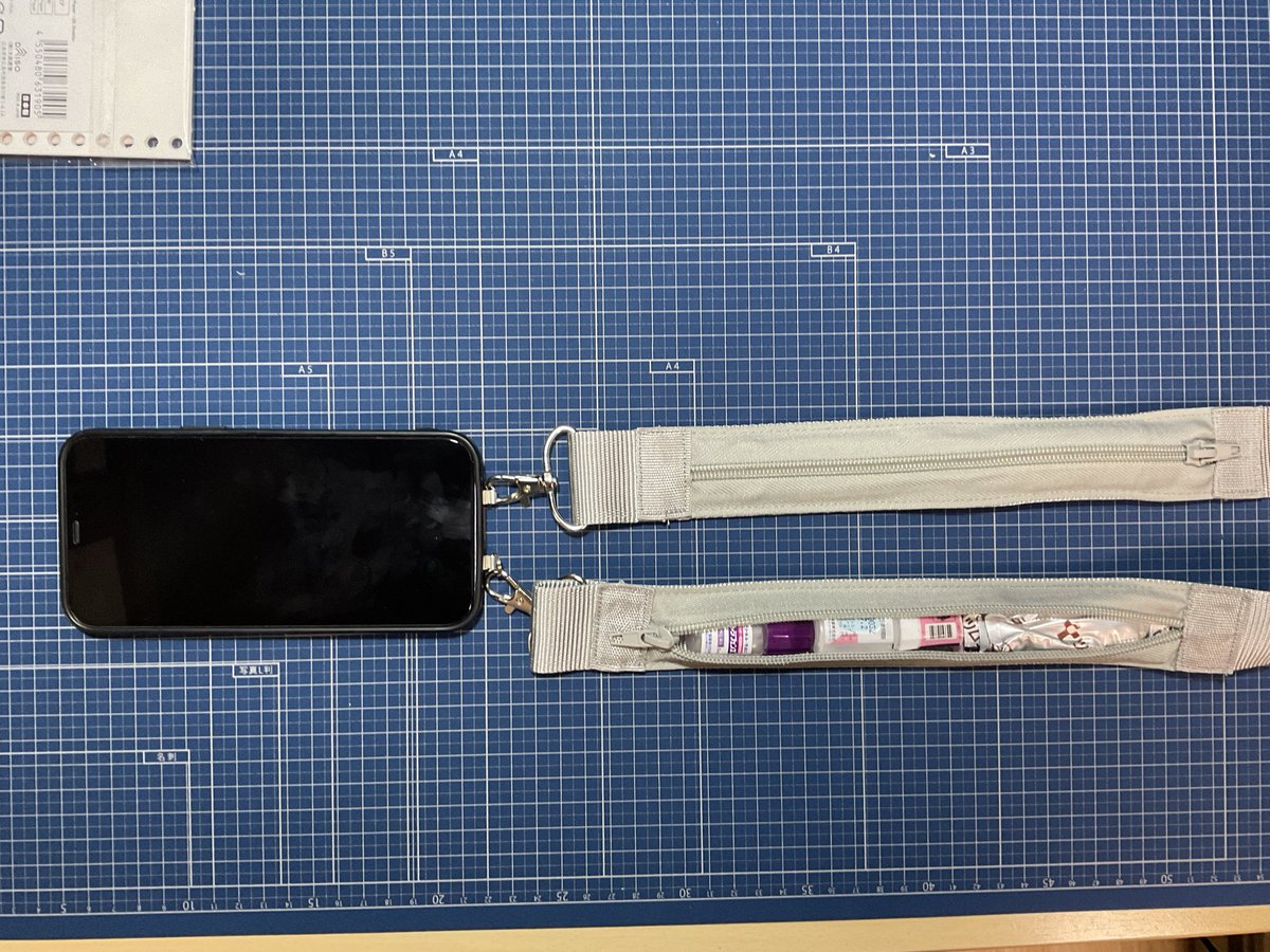 こういうやつ。幅広なので目立つけどそのぶん首肩痛くなりにくい。
金具の両端に20cmの長さのジッパータイプ小物入れついてる。伸縮性はない。長さ調整はできない。