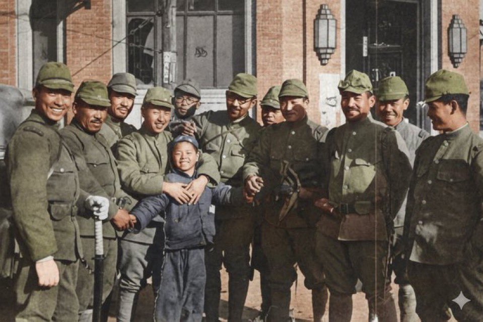 本圖為1937年12月16日由上野特派員於南京拍攝之照片的彩色化版本
這名中國少年的父親遭到中國軍隊綁架而使他成為孤兒。由於受到日本士兵的親切對待，少年便不願離開，據說還從砲聲隆隆的戰地一路跟隨部隊來到了南京