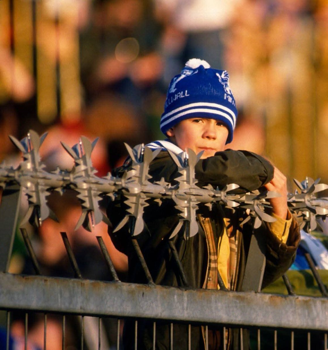 fussballgeekz's tweet image. A young #MillwallFC fan peers above the deathtrap fencing of The 'old' Den in 1988.
These brutal antiquities of the 80s game were subsequently removed in the wake of the 1989 Hillsborough disaster.