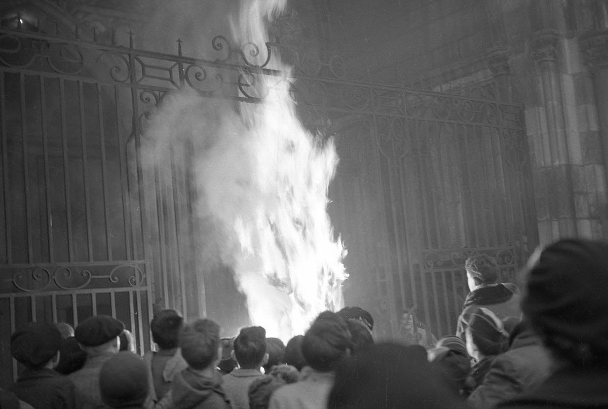 sonnysehra's tweet image. french catholics hanging and burning an effigy of santa claus in front of over 200 children to protest the “paganization” and commercialization of christmas (1951)