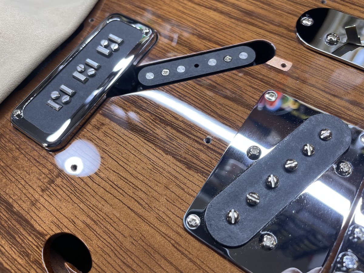 mtguitarworks's tweet photo. ブリッジPUには、当工房で製作しているソエジマトシキさんのシグネイチャーPU「STP90」を、テレキャスターPUサイズにアレンジした「Tee90」を採用しています。
特製マウントリングに搭載し、Gotohトレモロに In-Tune サドルを組み合わせたカスタムブリッジとセットで使用しています。
両PUの間のピックガード下にはノイズキャンセル用のダミーコイルを搭載し、2つのノブの間にフラッシュマウントしたトグルスイッチによって、ノイズキャンセル効果を3段階で切り替えられるようになっています。
また、トーンポットは引き上げることで通常のハイカットからローカットトーンに切り替わり、ローを削ってスッキリさせたい場面で有効です。