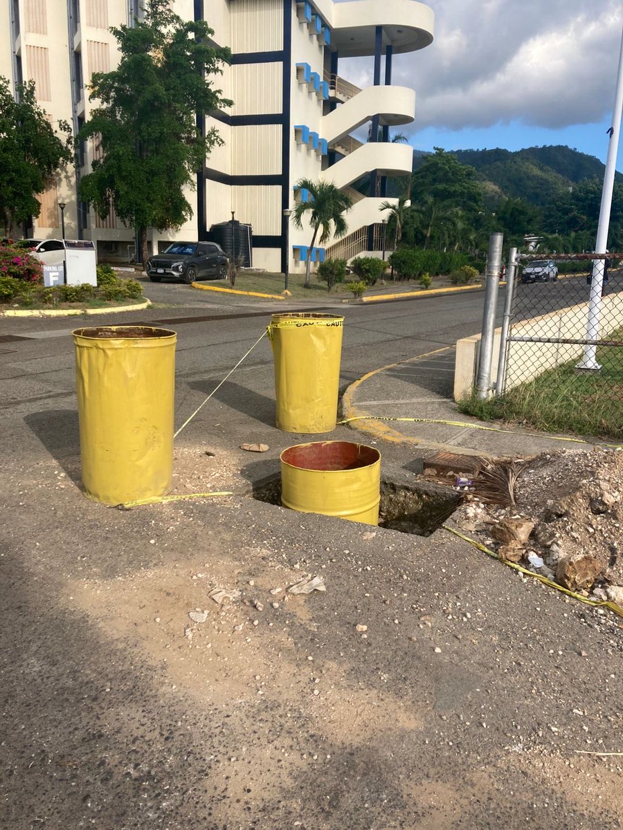 CAT2012Press's tweet photo. A safety cone marks an uncovered hole near the playfield entrance on the Utech campus, along a walkway used by students accessing nearby academic buildings and recreational areas.

#RoadSafety #Papine #UTechJA https://t.co/Qi9XBrlFpH