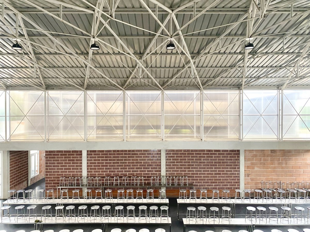 Architizer's tweet image. This community center replaces the typical industrial shed with a modular concrete-and-steel structure where hollow clay block jaalis drive natural ventilation and light. It introduces a climate-smart building language that’s easy to maintain and adapt.

📍Channarayapatna, India…