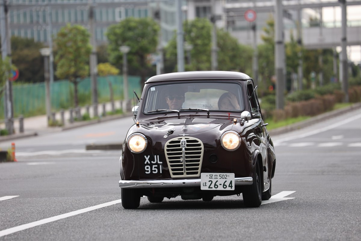 Brown beauty cutting through Tokyo’s streets like it owns the place. Driver locked in, passenger waving hello - classic style doesn’t need to shout. September 27th, 2026 – your turn to take the wheel.

📸 Kunihiko Horiguchi
🌎 Japan, Tokyo