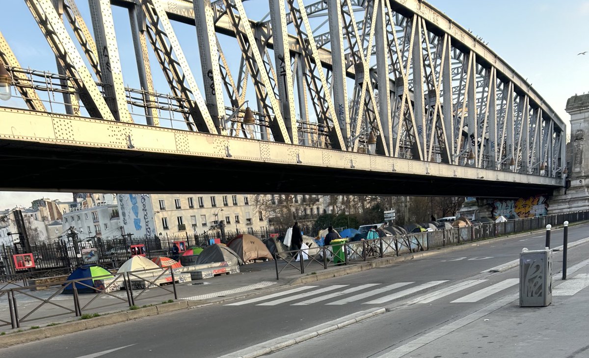 La misère à Paris en 2025 : 

- chantier de rénovation en toiture à quelques mètres du camp de ⛺️ du pont Saint-Ange,

- récupération de déchets « bois »,

- alimentation des braseros du camp sous le métro <a href="/Ligne2_RATP/">Ligne 2</a> 

- une odeur typique de🔥 dans tout le quartier …