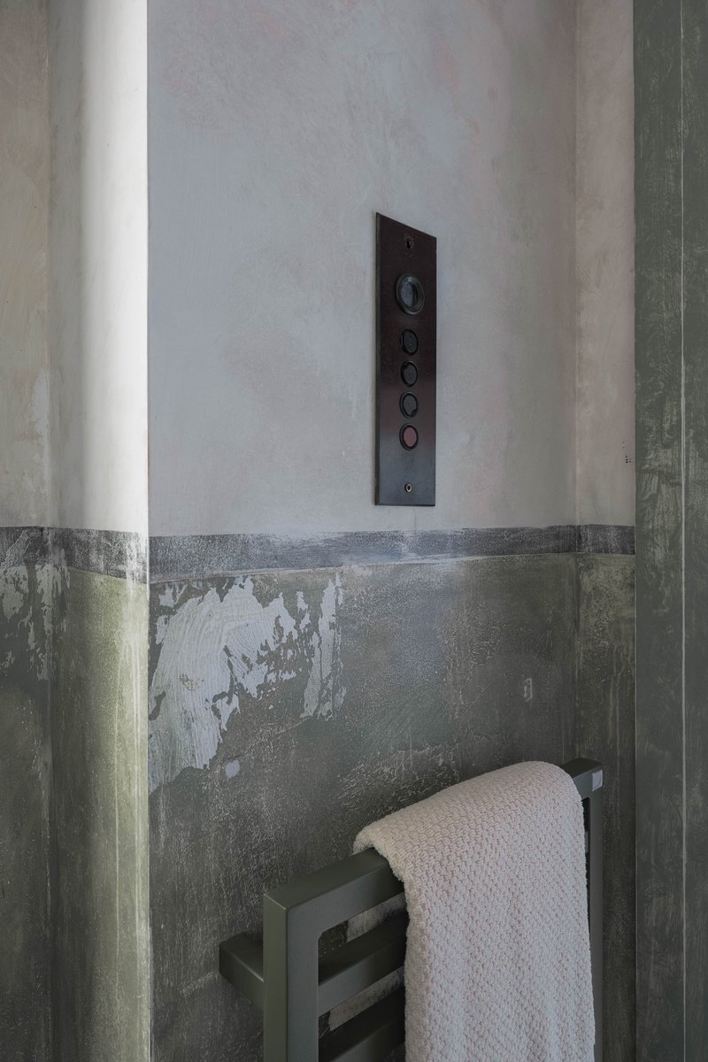 In Kinbuck village, a 200-year-old carding and spinning mill has been reimagined as a family home. The downstairs cloakroom occupies the former lift shaft, with original brass push buttons retained, hand-aged paintwork and antiques adding layered character.