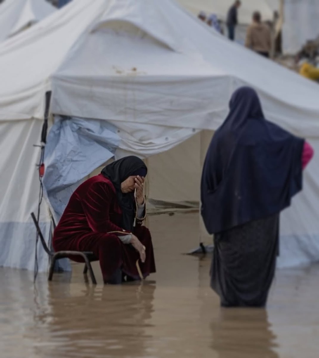EyeonPalestine's tweet image. A mother sits before her tent, flooded with water… the sorrow of winter weighs heavily on her heart.