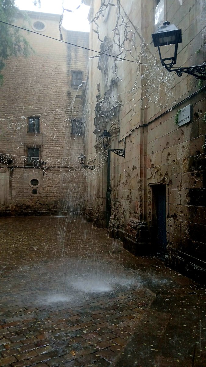 Absolutely bucketing it down today in Barcelona, the marks of Mussolini's murderous bomb behind on the façade of Sant Felip Neri.