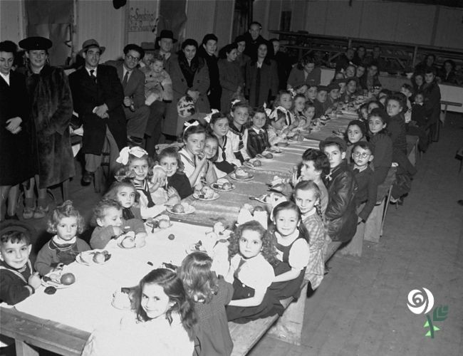 HolocaustCentUK's tweet photo. For the sixth day of Chanukah, we share this image from 1947, showing a Chanukah party for Jewish children at the Finkelschlag DP camp in Fürth, Germany. The gifts the children received were donated by families of American servicemen stationed in Nuremberg, bringing moments of light after years of darkness.

(Image source: United States Holocaust Memorial Museum)