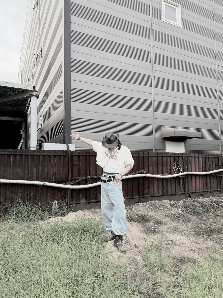 Twildight's tweet image. Rockin’ a proper fit, cowboy hat tipped low, layered chains on show, cropped hoodie and baggy denim. Posted up by that rough wall like it’s a runway, lookin’ effortlessly cool?