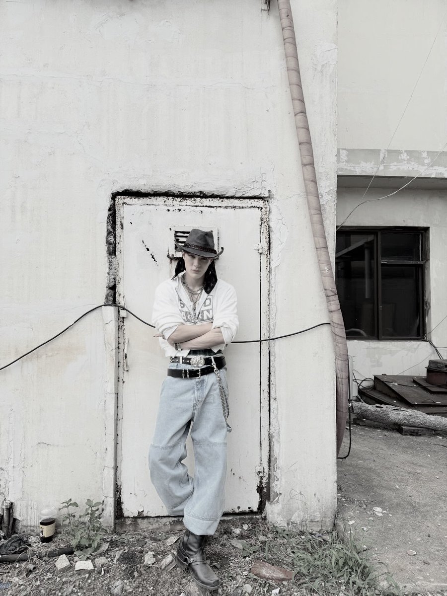 Twildight's tweet image. Rockin’ a proper fit, cowboy hat tipped low, layered chains on show, cropped hoodie and baggy denim. Posted up by that rough wall like it’s a runway, lookin’ effortlessly cool?
