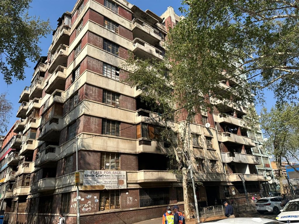 matinyarare's tweet photo. 𝗛𝗜𝗝𝗔𝗖𝗞𝗘𝗗 𝗕𝗨𝗜𝗟𝗗𝗜𝗡𝗚𝗦 𝗔𝗥𝗘 𝗔 𝗚𝗢𝗟𝗗 𝗠𝗜𝗡𝗘, 𝗔𝗡𝗗 𝗪𝗔𝗥𝗥𝗔𝗦 𝗪𝗔𝗦 𝗗𝗜𝗦𝗥𝗨𝗣𝗧𝗜𝗡𝗚 𝗧𝗛𝗘 𝗠𝗢𝗗𝗘𝗟.

What many South Africans do not realise is that a large number of buildings in the country’s major cities—particularly Johannesburg, Randburg, and Pretoria—are owned by German and Dutch businesspeople who now live in Cape Town or Europe. Since leaving South Africa, many of these owners no longer maintain their buildings and fail to pay municipal rates or electricity to councils.

To maximise profits, most owners employ mainly Zulu or Sotho gangs (commonly referred to as AmaRussia) to pose as building hijackers. This arrangement allows the owners to distance themselves from responsibility and avoid paying rates and electricity. These “hijackers,” who effectively act as agents of the foreign-based owners, then subdivide two- or three-bedroom flats into 10 to 15 cubicles using curtains or wooden partitions. A single sitting room can be converted into four or five cubicles. Some buildings are also turned into brothels, where women sharing rooms are charged up to R200 per day, or about R18,000 per room per month.

The gangs illegally bridge electricity from City Power infrastructure or neighbouring buildings, and the cubicles are then rented out—mostly to foreign nationals working menial jobs—for between R800 and R1,000 per month/cubicle.

In essence, owners pay enforcers to transform their properties into shack-like slums or “curtain hotels,” where a three-bedroom flat in Hillbrow can generate between R14,000 and R18,000 per month.

Zulu or Sotho gangs act as rent collectors and enforcers, but they are themselves monitored by violent private security companies, many owned by former white South African police officers. These security companies also maintain relationships with separate Zulu and Sotho gangs that are reportedly used to eliminate hijackers or agents who no longer serve the owners’ interests.

The bulk of the money collected from these buildings is sent back to the owners in Cape Town or Europe, who pay no municipal rates, electricity, or estate agents to manage the properties.

When owners later decide to sell, they often instruct lawyers to claim that their buildings were hijacked. This results in municipal councils scrapping accumulated rates debt, after which the owners regain control of the buildings. The properties are then bought by entities such as Joburg Property Company, refurbished, and the cycle begins again on another building.

There are reports that some Zulu taxi owners have caught on to this model and have begun pooling their money to purchase old buildings and replicate the same system.

In buildings with as many as 400 flats, monthly collections can reach up to R5.6 million without paying for maintenance, electricity or rates. Hijacking buildings and turning them into slums is far more lucrative than managing them as well-maintained, law-abiding, rate paying properties. This is the economic logic behind building hijackings. It’s a money spinner.

The model is especially lucrative because owners incur no costs for maintenance, municipal rates, or electricity. All the money goes directly into their pockets and a fraction to the enforcers. Tenants who fail to pay are violently evicted, their deposits withheld, and replaced immediately—and the new tenant is often required to pay a two-month deposit—without any legal eviction process.

Contrary to popular narratives, no foreign nationals control buildings in South Africa. Even Nigerian drug dealers are merely tenants of the local kingpins, because they lack the numbers and organised gangs required to control Johannesburg or Pretoria.

By attempting to clean up Johannesburg and remove undocumented immigrants—who are the most lucrative tenants for these building owners—Warras was stepping on the toes of extremely wealthy international property owners who profit from immigrant-occupied slums in South Africa.