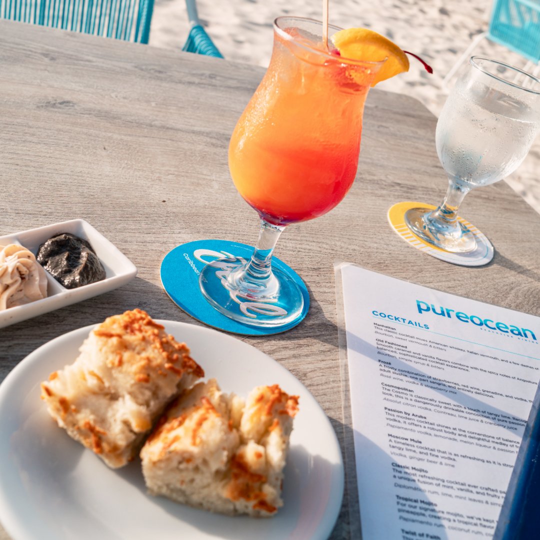 Warm bread, creamy butter, a handcrafted cocktail, and an Aruba sunset. Now that’s how you start dinner at pureocean. 🌅🍞🍸

#pureoceanAruba #SunsetSips #DinnerWithAView #ArubaEats #ArubaRestaurants #ArubaBeachFrontRestaurants