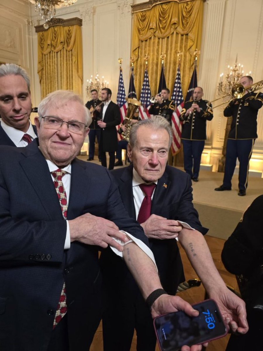Awesome_Jew_'s tweet image. Holocaust survivors pose at the White House Hanukkah party, displaying the concentration camp tattoos they carried through history. A powerful and inspiring moment.