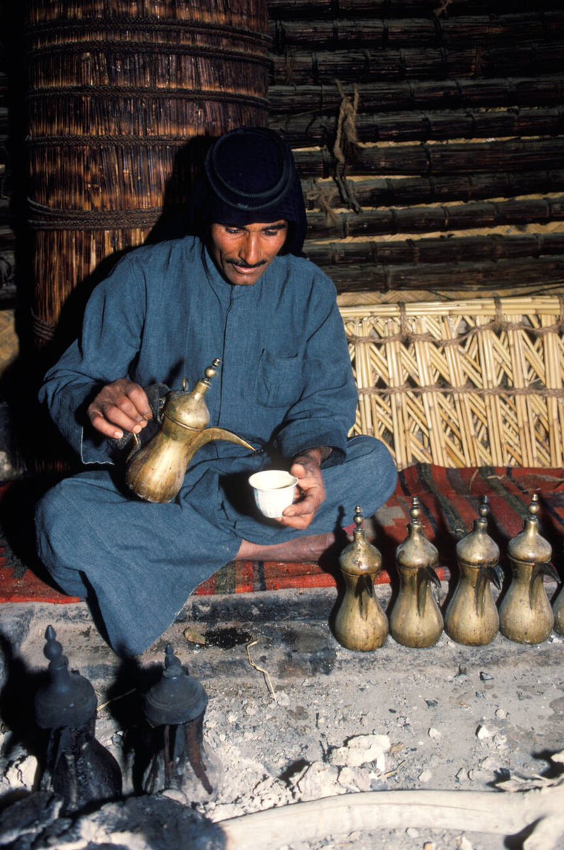 Marsh Arab man Iraq, in reed house with a line of coffee pots. 1984. Southern Iraq Near Basra. — by/Homer Sykes.