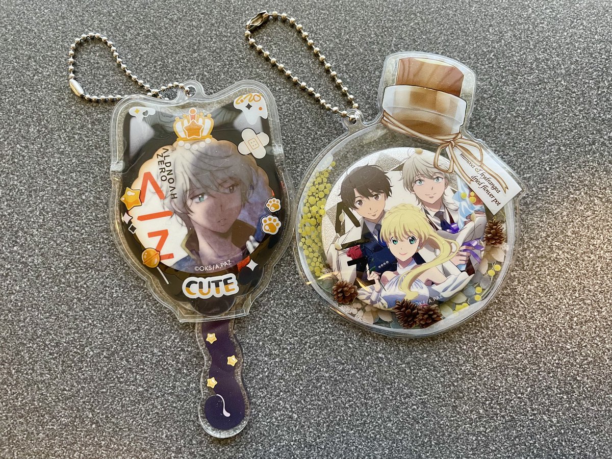 缶バッジケースに入れてみた 左側のスレの缶バッジ、黒にオレンジ色の