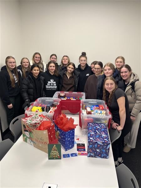 Female U18 Prep team values the gift of giving and the strength of community in preparing their Christmas Cheer Board bin. 
￼