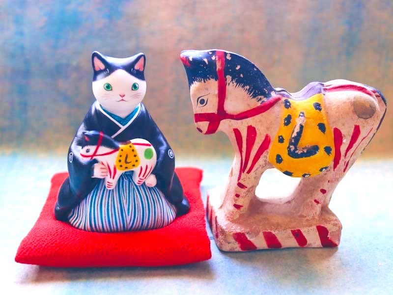 猫が抱いている馬の謎の「し」は鞍のあぶみです。 馬のモデルは長崎の