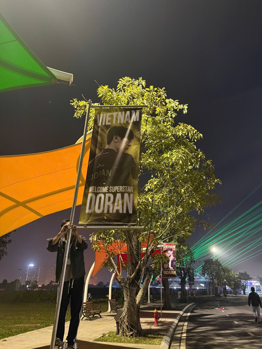 RawiDoranie's tweet photo. We’re in the final rush, putting every detail in place to welcome our Super Star, Doran ⭐️

🏳️ 16 street banners, 8 different designs, 8 seasons Doran has walked through so far… and beyond.
Every banner tells a story. Every season leaves a mark.

🌼 We hope Doran’s future continues to be paved with flowers — bright, brilliant, and filled with glory✨

📌Location: In front of Halls 1–2, VEC — the event venue

#Doran #WelcomeDORANtoVietnam #T1 #T1inVietnam
