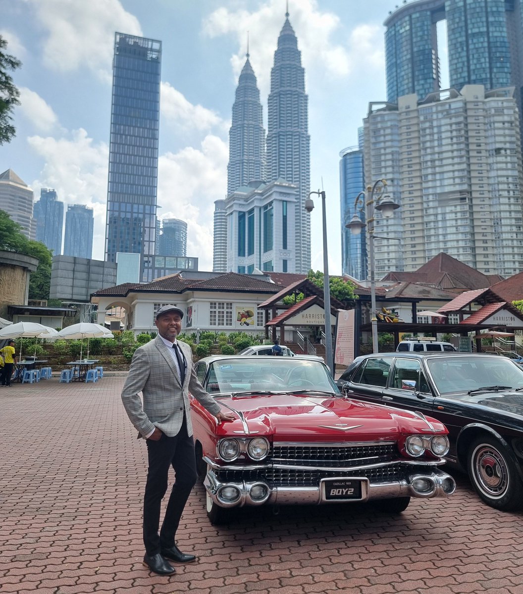 Two classics, one dapper gent, and Kuala Lumpur’s skyline making everything look effortlessly cool. That red beauty isn’t shy, and neither is our September 27th invite. Suit up, join in.

🌎 Malaysia, Kuala Lumpur
