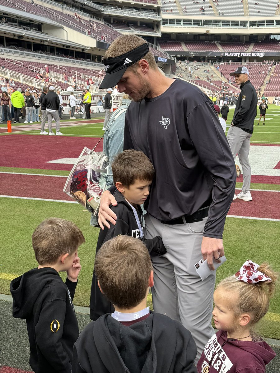 kolton_becker's tweet photo. Collin Klein hugging his kids pregame before he coaches his final game at Kyle Field before starting his new position at Kansas State. #CollinKlein #Aggies #KansasState https://t.co/NsAEn3Oiu3