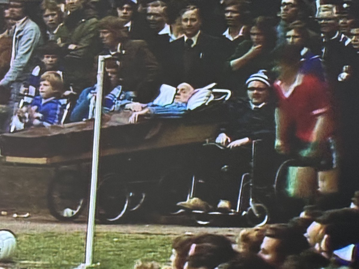 A bloke in an actual bed (on wheels) watching Ipswich v M Utd, 1976.