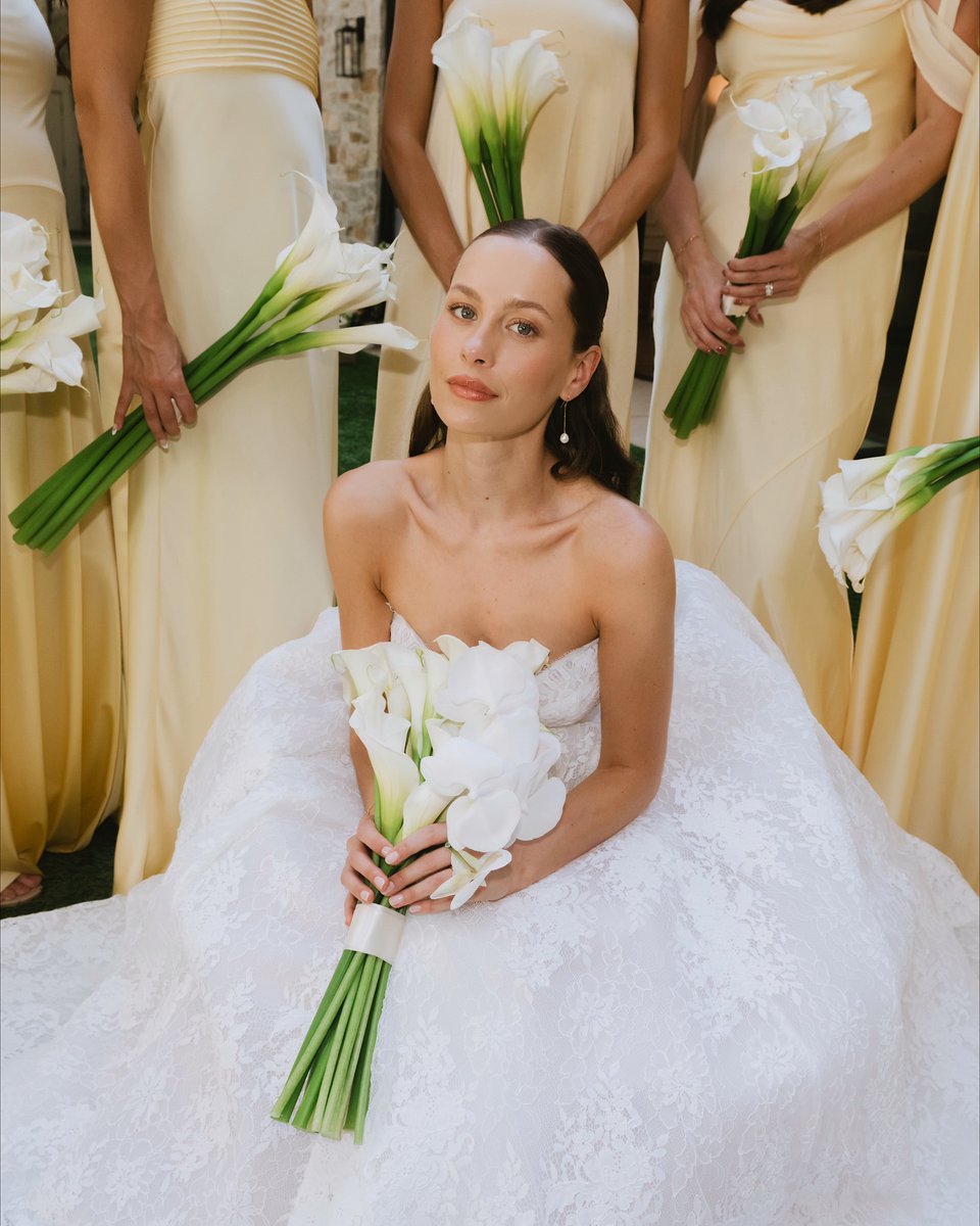 A moment of calm before the celebration ✨ Surrounded by her bridesmaids, @natashaperry's classic lace gown and sculptural calla lilies create the perfect timeless bridal look 🤍 

Your dream wedding starts here at FBFW