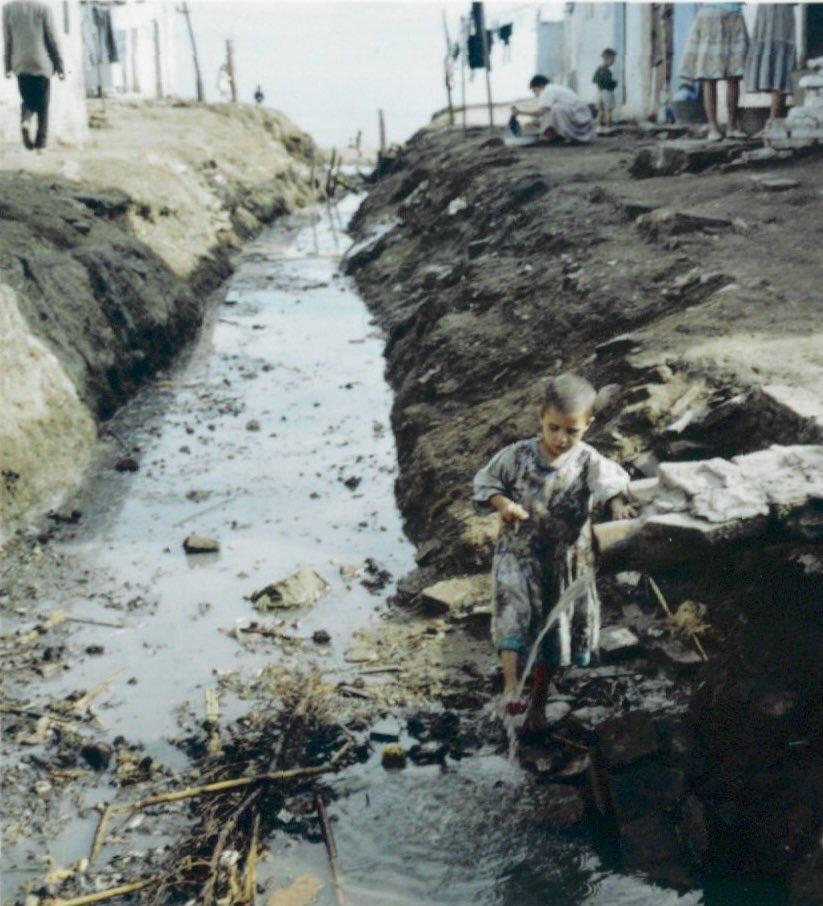 Barcelona 1962. 

Un nen es neteja els peus amb aigues brutes a la platja del Somorrostro, situat a l’actual barri de la Vila Olímpica. 

Els habitants de l’assentament de barraques del Somorrostro van ser reallotjats al barri de Sant Roc de Badalona. 

📸Joan Miquel i Quintilla