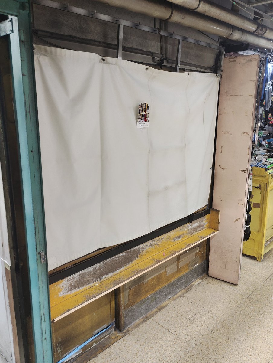 koubashimachi's tweet photo. ｢あとにのこるもの｣
　
　つい半月前まで、たった一坪の書店があった。90歳の老婆が親子で74年間営んでいた。
　擦り切れたラック。閉じた出入口。
　もう、店主が立つことも本が並ぶこともない。

　閉ざされた幕に挨拶が短く一言。
　賑わう中、誰も気に留める人はなく。。

2026年1月撮影・東京 https://t.co/nls0bClqWh