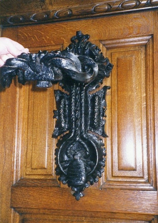 El símbol polític queda completat amb un detall extra i és que al centre del picaporta hi ha un altre escut de Catalunya amb les 4 barres, com el de pedra sobre el portal. Quan piques la porta la xinxa castellana queda esclafada entre la Creu de Sant Jordi i l'escut de Catalunya.