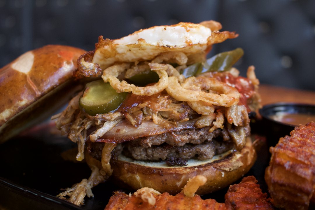 dccobbs's tweet photo. D.C. Cobb's challenges you to try the Hart Attack! 🍔🔥Pulled pork, fried egg, black forest ham, onion strings, BBQ &amp; jalapeños piled on a pretzel bun! Are you brave enough? #DCCobbs #HartAttack #FoodChallenge 🚑🌶️ https://t.co/1Vx3PueKbu