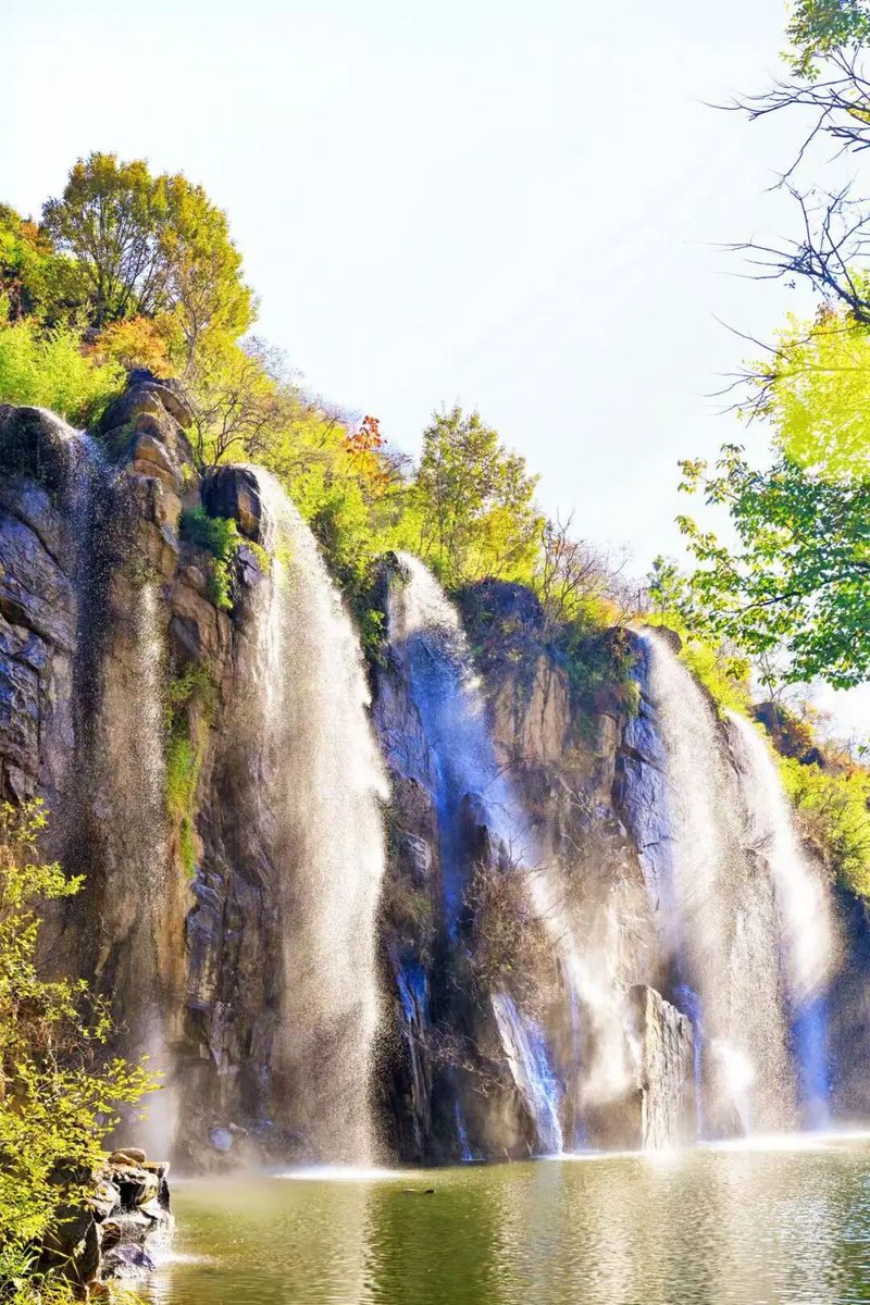 Dawn breaks over Yuwan Scenic Area, Lianyungang, where soft mist dances like silk🌫. Above the emerald waters of Sanlongtan, the winter waterfall transforms from a roar into a delicate shimmer✨, reflecting the morning light like polished glass.