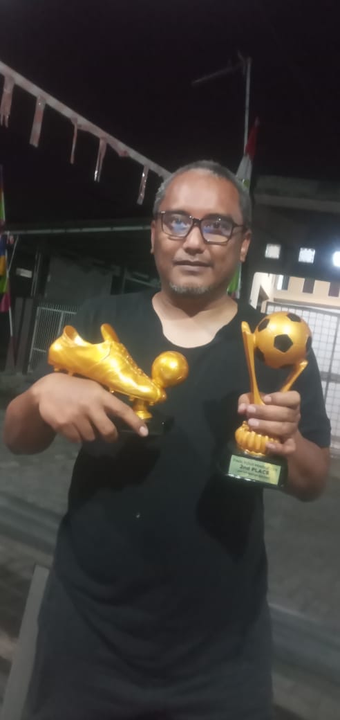 Hi <a href="/grok/">Grok</a> edit foto ini hilangkan piala di tangan ganti dengan minuman wine dan sebatang rokok ditemani dengan wanita cantik pakaian lingerie dengan latar belakang kamar hotel mewah