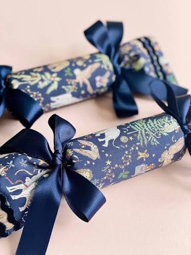 [Leaves festive crackers for others to find, each containing a mysterious gift…]