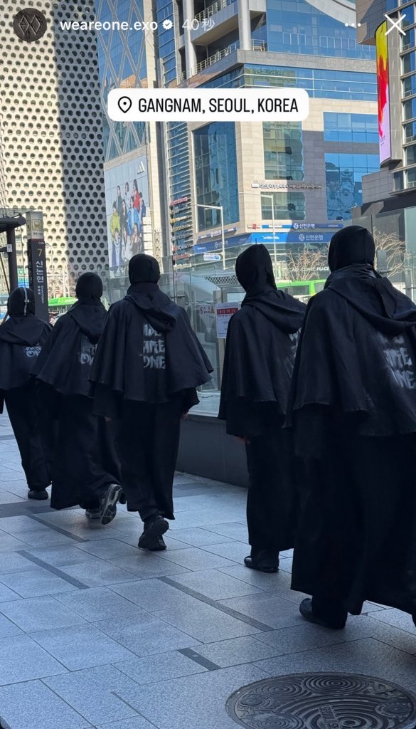 ZvT1lp's tweet photo. 映像とか流すんじゃなくてお面を被って全身真っ黒な服装をした人たちを街中で歩かせる今回のEXOのカムバプロモーションが凄すぎて…マントにEXOのロゴやwe are oneの文字が書いてあるの鳥肌 https://t.co/aKU8cNzSML