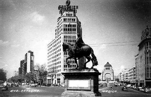 "Caballito" Estatua ecuestre de Carlos IV.
Estuvo en la glorieta de Bucareli desde 1852 hasta 1979.
Tercer parada del caballito que ha cabalgando por 
la
ciudad.
El edificio Corcuera se le ve su gran letrero Goodrich y la llanta emblemática.
Al fondo el momento a la Revolución.