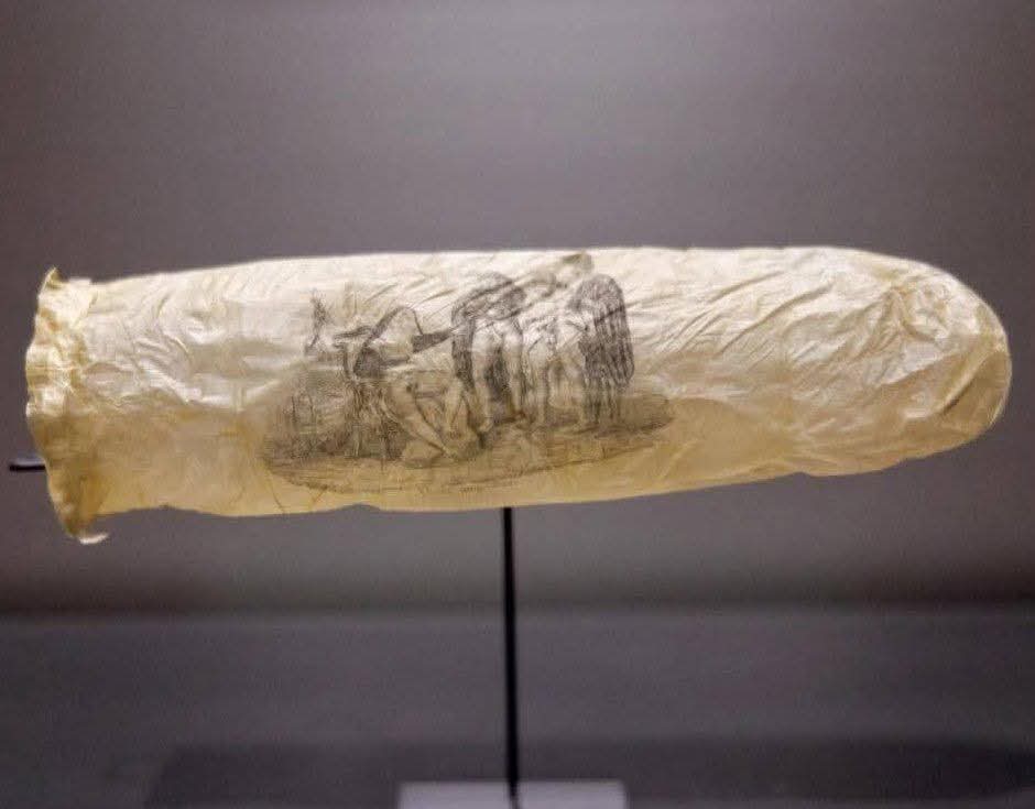 Condón de 200 años de antigüedad, que se cree fue fabricado alrededor de 1830 a partir del apéndice/tripa de una oveja.

El condón está decorado con un grabado erótico que representa a una monja y tres clérigos en una escena provocativa, junto con la frase francesa "Voilà, mon