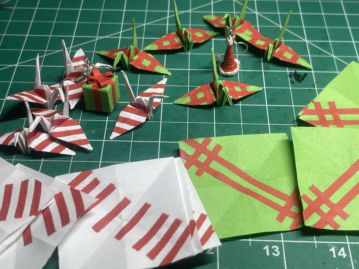 PaperPerci's tweet image. Christmas Cranes! A lil late of a post but made these cranes for the holidays. Lil gift wrapped cranes and some peppermint candy cranes! Also recently made another pair of cubes and have been testing out some 2d shape earrings to see how they hold up.