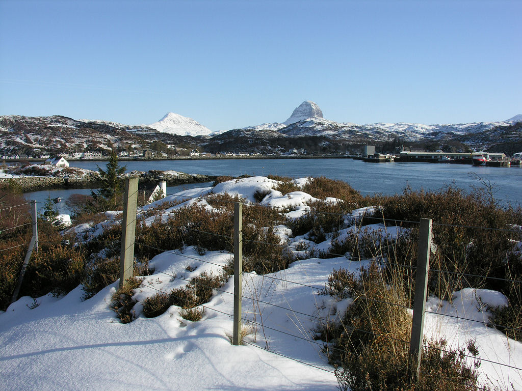 UndisScot's tweet photo. A wintry view across Loch Inver on the west coast of Sutherland to the village of Lochinver, the largest settlement on the west coast of Scotland north of Ullapool. Beyond the village are the mountains of Canisp and Suilven. More pics and info: https://t.co/h4MnmSEEJd https://t.co/Mo4KtPRI6S