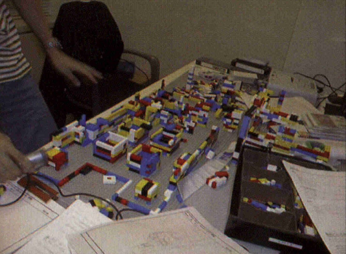 MGSMGN's tweet image. Director Kojima and Yoji during the early days of Metal Gear Solid’s development. Bonus photo shows Kojima’s LEGO layouts for MGS, mapping the docks and cargo area on Shadow Moses Island and the entry route leading to the lift.