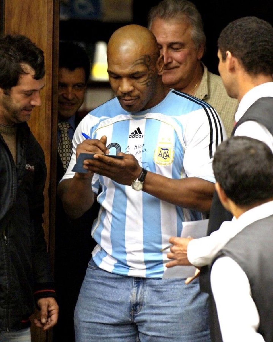 Collect's tweet photo. Mike Tyson testified at a courthouse in Brazil wearing a signed Maradona jersey 😅

In 2005, after an altercation with a local news cameraman in São Paulo, Brazil, Tyson was summoned to a Brazilian court to pay damages. 

He showed up wearing a jersey signed by Diego Maradona, gifted during an appearance on Maradona’s TV show, “La Noche del 10.”

The move shocked fans, given the intense football rivalry between Brazil and Argentina, making his court appearance instantly unforgettable.