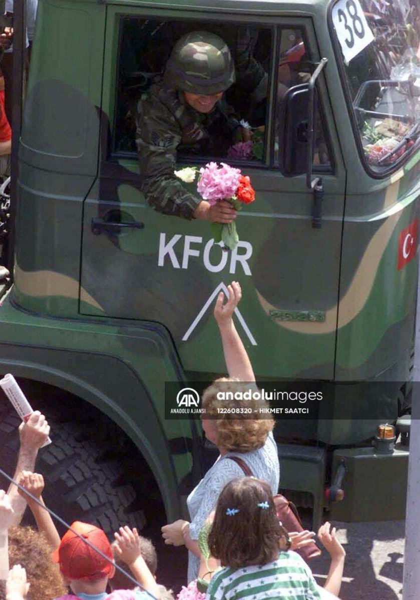 Locals give flowers to Turkish soldiers entering Kosovo, 1999.
