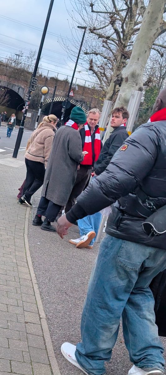NolanAnalyst's tweet image. Christopher Nolan near the Emirates Stadium, wearing an Arsenal scarf.