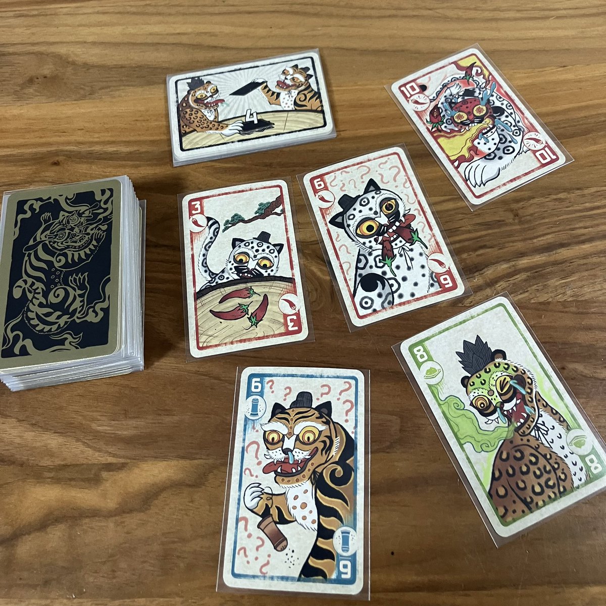 nusfrog's tweet image. 明けましておめでとう御座います🎍
干支違うやんって🐅→🐎所ですが、金ピカかつ絵柄がめでたい感じなので🌟
人数に合わせて山札のこの高さに「ゲーム終了カード」を差し込んで、、、がスリーブ入れてるから厚み変わっちゃってる感あるけど、気にせずに今年も『スパイシー』取り組みます🔥🌶️🐯