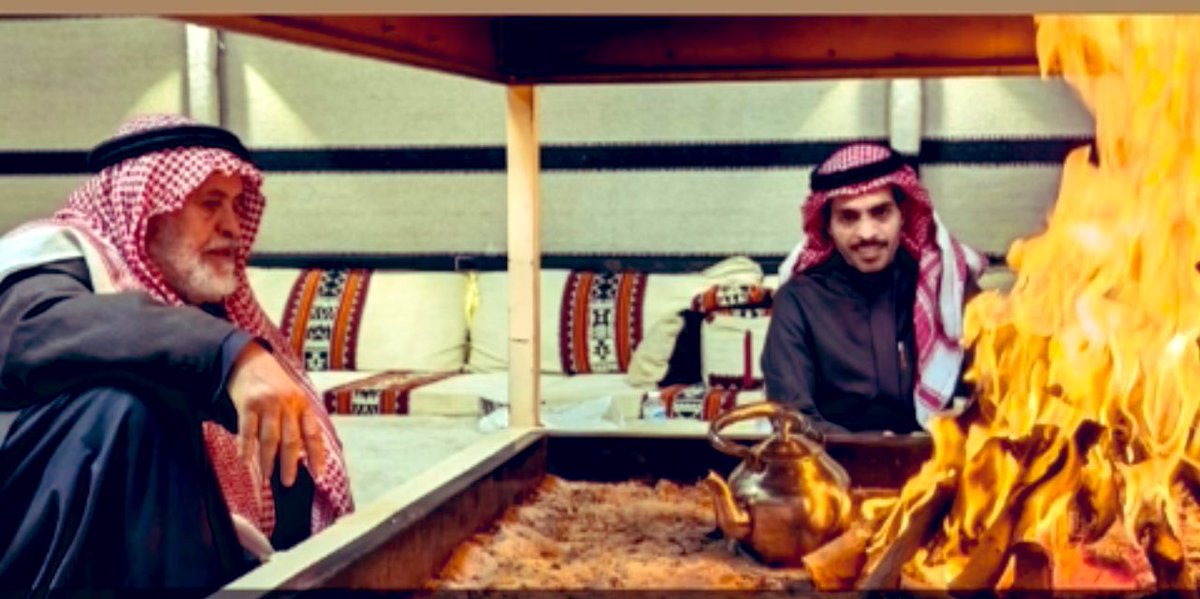 في أعماق الصحراء، حيث يلتقي الهدوء بالنجوم، يجلس العم سعد الجش مع ابنه عادل يروي قصص الأجداد.
هذه الجلسة ليست مجرد استراحة من برد الشتاء، بل هي مجلس حكمة. يتحدث العم سعد عن أيام الجاهلية والإسلام، عن الإبل والخيل، عن الوفاء والشجاعة. صوته هادئ لكنه قوي، يخترق صمت الليل، والنار