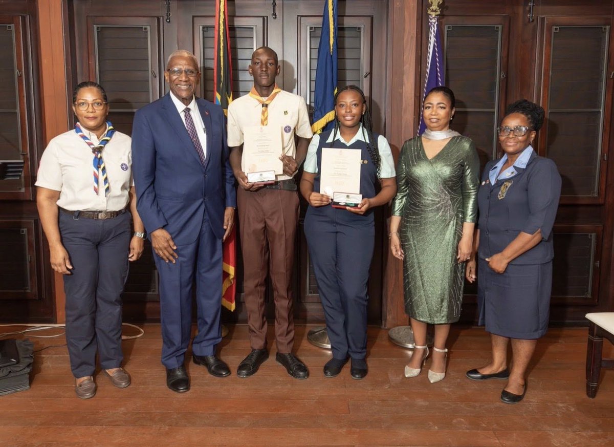 Two recipients accept the Halo Foundation Guiding Light Award for uniformed bodies

(1) H.E. Lady Williams with Girl Guide Kerisha Sweeney.
(2) H. E. with Scout Joshua Roberts
(3) Their Excellencies, the awardees and institution leaders, Patricia Salmon and Suzette Spencer-Burton