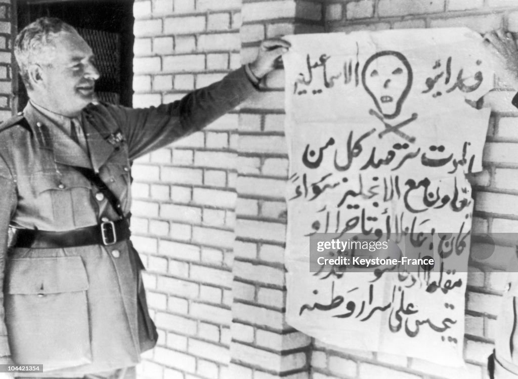 الجنرال إرسكين ، قائد القوات البريطانية في منطقة القناة  مصر ، يتفحص ملصقا يهدد بعقوبة الإعدام لأي شخص يتعاون مع الإنجليز , 15 فبراير 1951