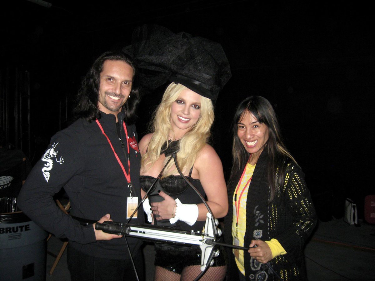 Britney Spears behind-the-scenes with crossbow professionals, Mr. \u0026 Mrs. G,  who helped her handle the prop during the filming for the Circus Tour intro  video, 2009., image size:1200x900