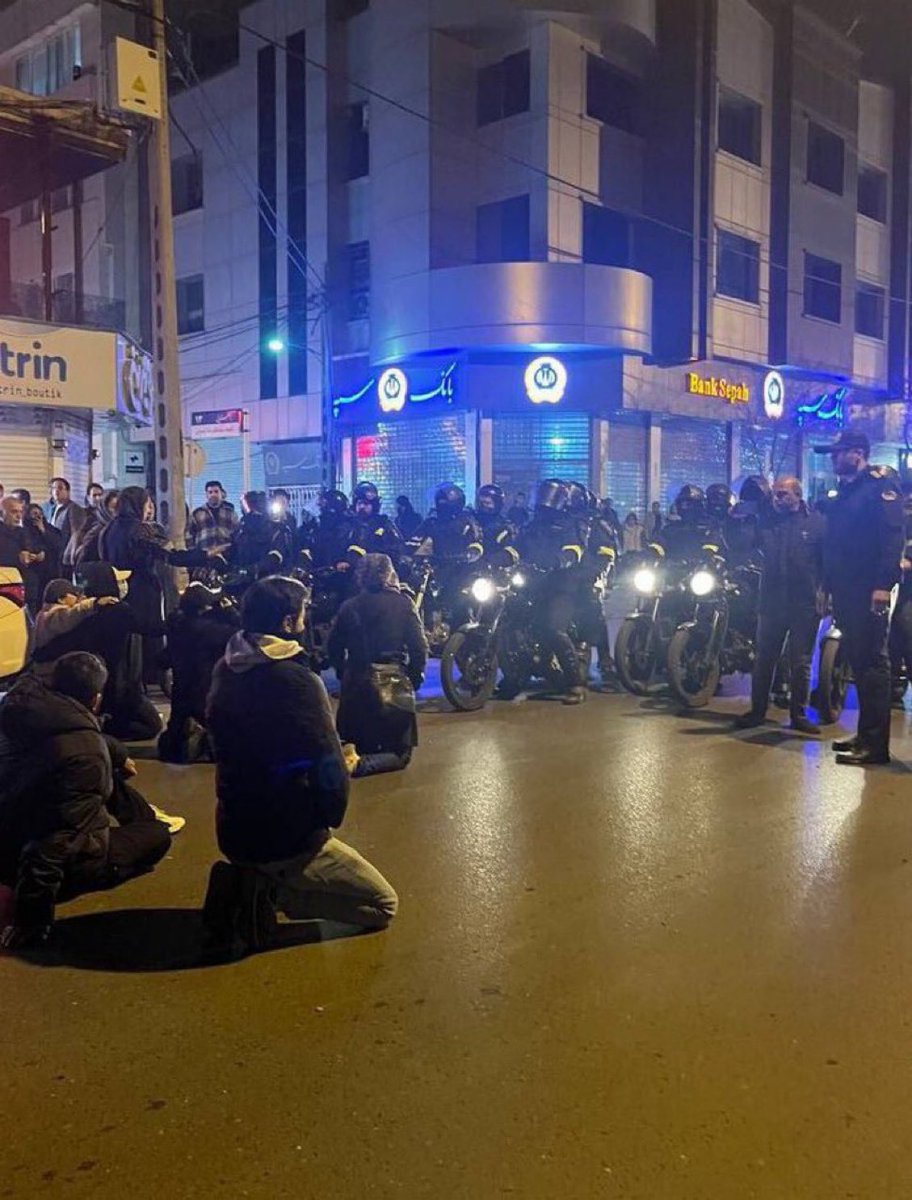 GhorbaniiNiyak's tweet photo. 🚨 BREAKING NEWS – MASHHAD | IRAN

In Mashhad, young Iranians are openly confronting IRGC units and regime security forces.

Footage shows groups of young protesters sitting down in the middle of the streets, in full view of armed forces, calmly, openly and without fear.

Unarmed and defenceless, they are choosing a powerful form of resistance:
they sit, they remain, and they refuse to retreat.

They are not running.
They are not hiding.
They are showing the world that they are not afraid.

This act has become a striking symbol of courage and defiance, as Mashhad continues to stand at the heart of the nationwide uprising.